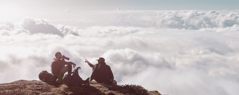 Montañeros observando un mar de nubes