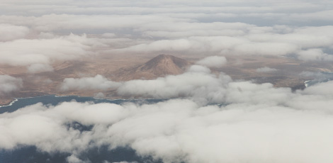 Plano aéreo de uma ilha de Caboverde, paisagem com vulcões e nuvens