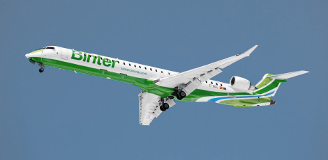 Modelo CRJ con colores de Binter volando y visto desde tierra