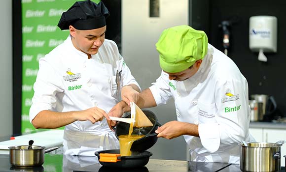 Two chefs collaborating during the Binter cooking competition.