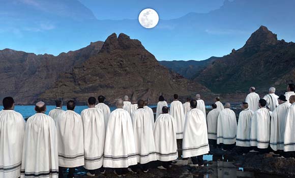 Foto de los integrante mirando hacia la luna frente a un paisaje de montañas