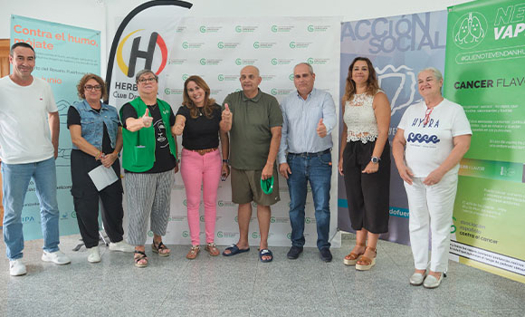 Group of people giving a thumbs-up gesture in front of a promotional background.