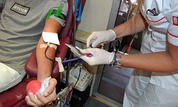 Scatto di un volontario che dona il sangue all'interno di un autobus