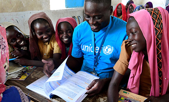Une volontaire de l'Unicef forme un groupe de filles.