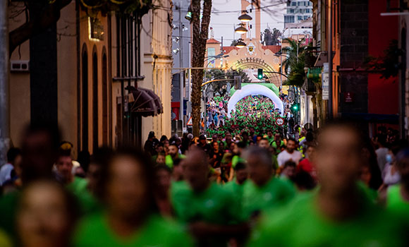Plano de uma rua em Santa Cruz de Tenerife cheia de corredores com t-shirts verdes.