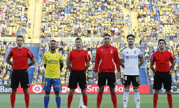 Foto de familia con árbitros y jugadores La Unión Deportiva Las Palmas al inicio de un partido